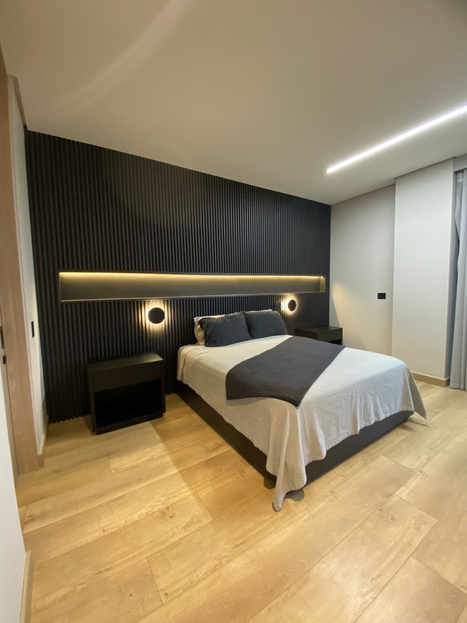 A beautifully styled room featuring the Black Decorative Wall Panel - WPCBancal, adding a sleek, modern aesthetic with its elegant finish and seamless installation on the walls.