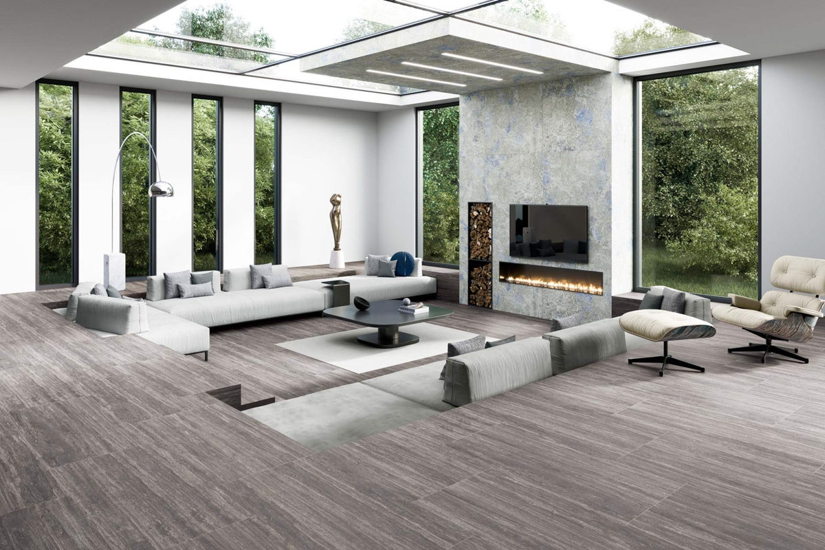 A spacious modern living room features a grayish wood floor that extends throughout the room, suggesting a durable and easy-to-maintain material for a high-traffic space.