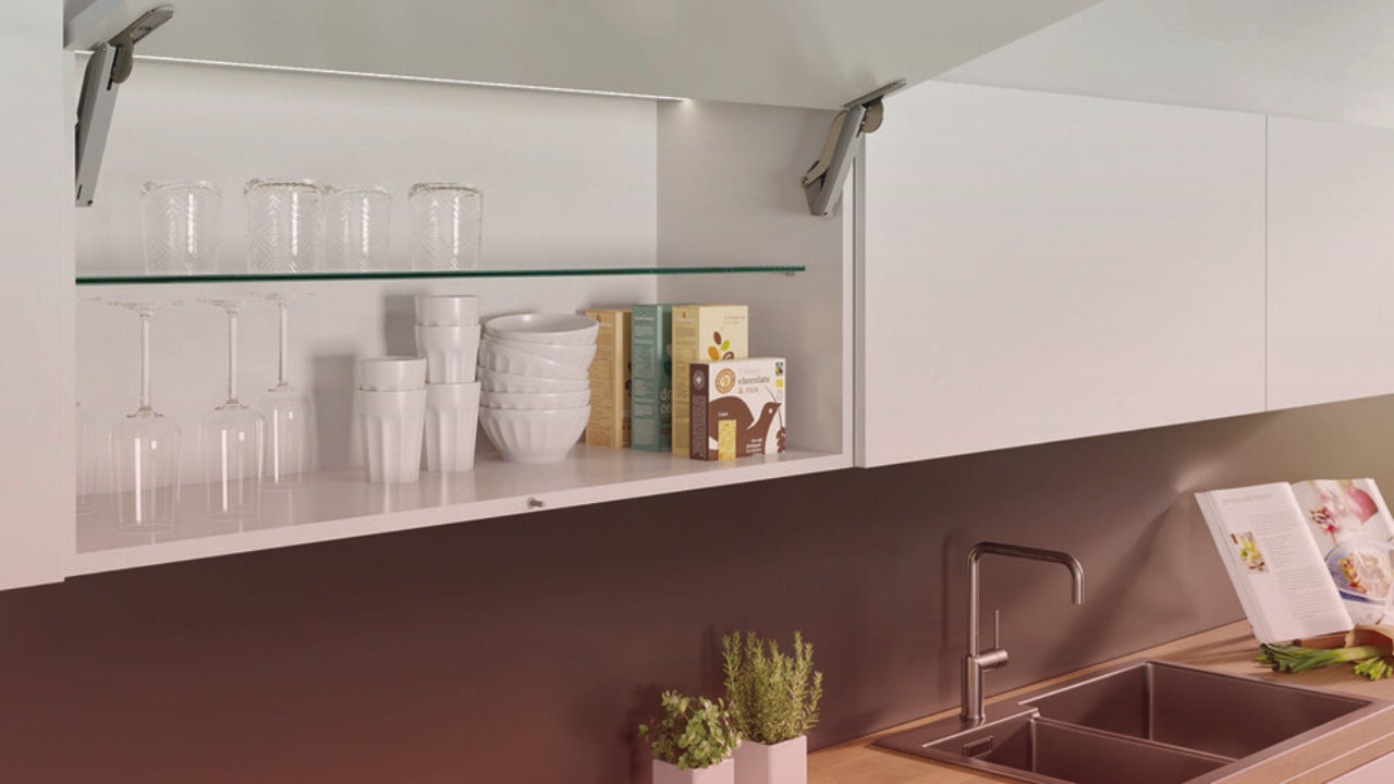 Modern Häfele kitchen hardware cabinet with lift-up door, glass shelf, and organized dishes, perfect for contemporary homes in America.