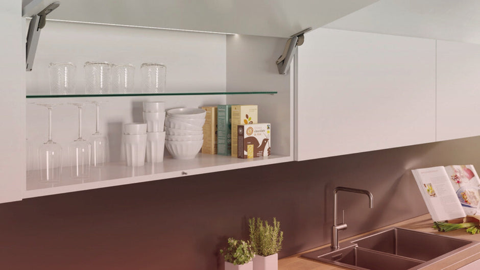 Modern Häfele kitchen hardware cabinet with lift-up door, glass shelf, and organized dishes, perfect for contemporary homes in America.